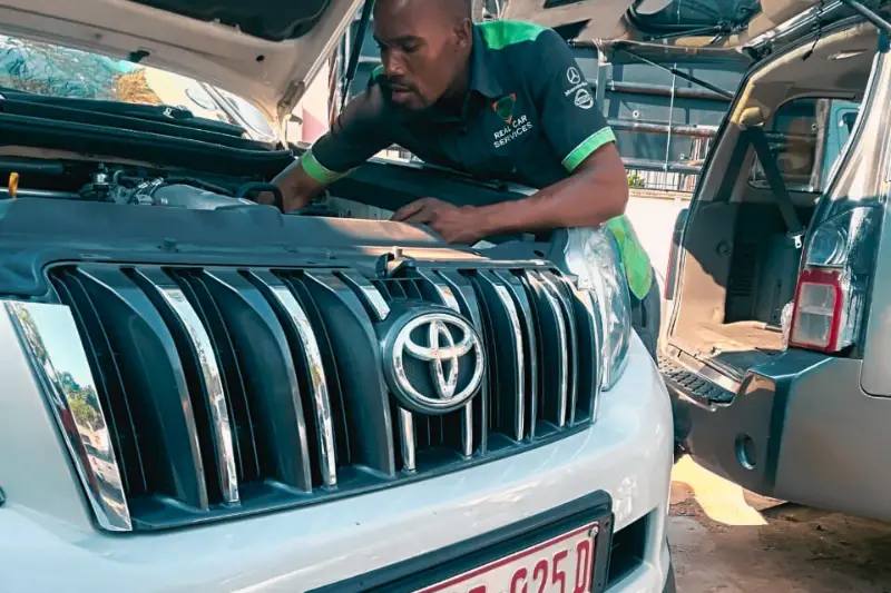 Technician inspecting a vehicle at Real Car Services